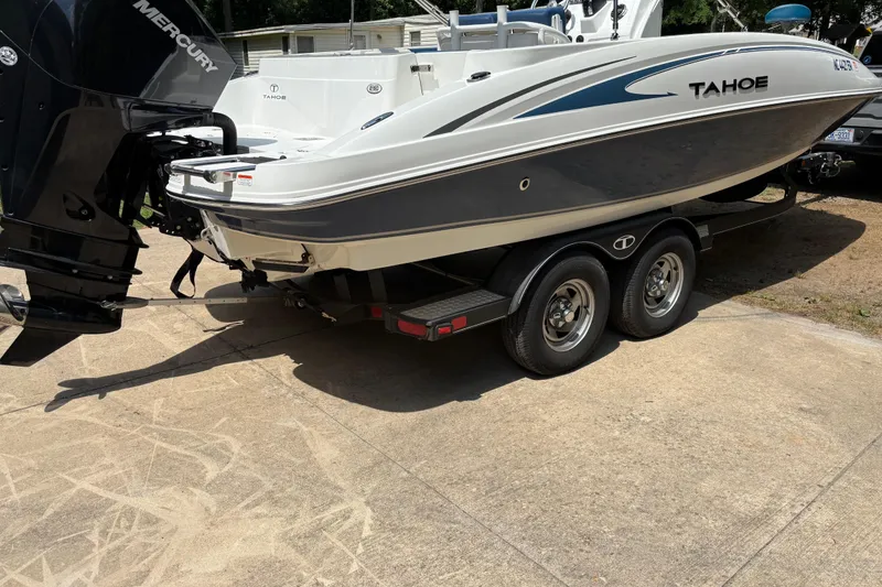 Slide: The Image of 2020 Tahoe 2150 CC boat on trailer with Mercury outboard motor, parked on concrete. - 6