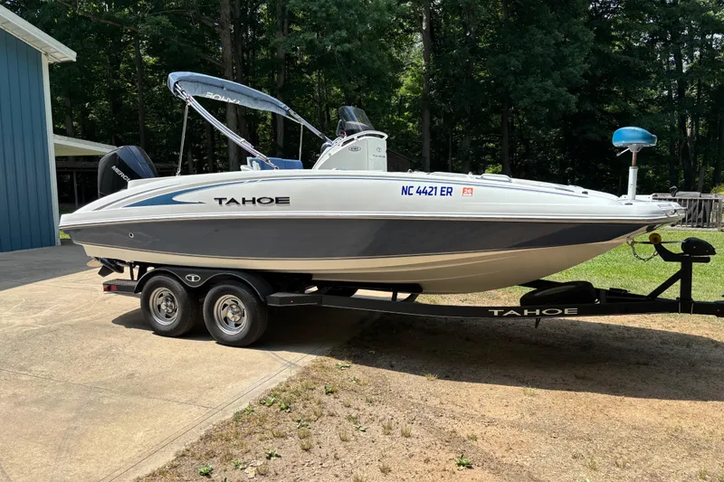 Slide: The Image of 2020 Tahoe 2150 CC boat on trailer, parked outdoors near a blue building. - 7