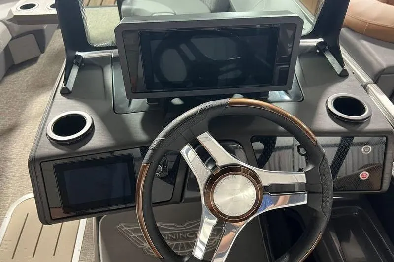 Slide: The Image of Steering console of 2026 Bennington 22 M Swingback with modern displays and cup holders. - 8