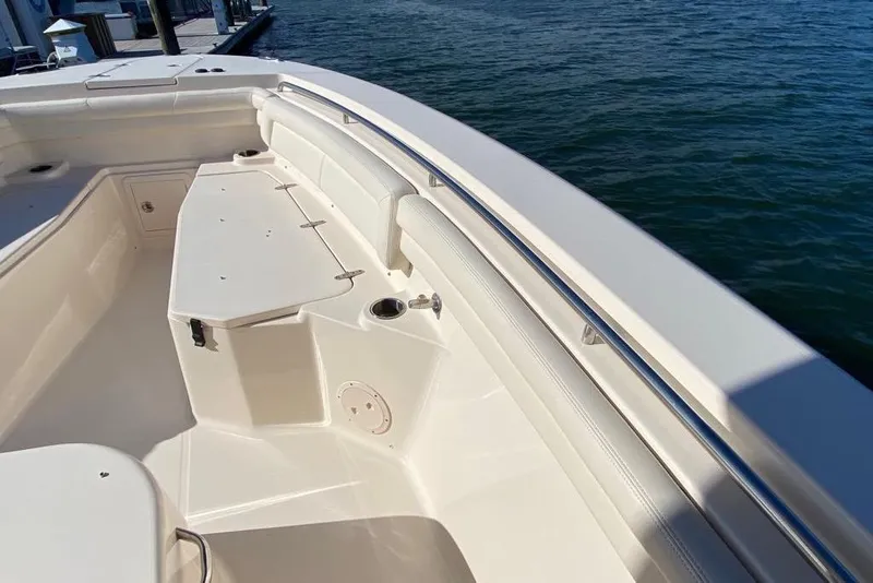 Slide: The Image of 2016 Grady-White Canyon 336 boat interior with seating and storage, docked by the water. - 32