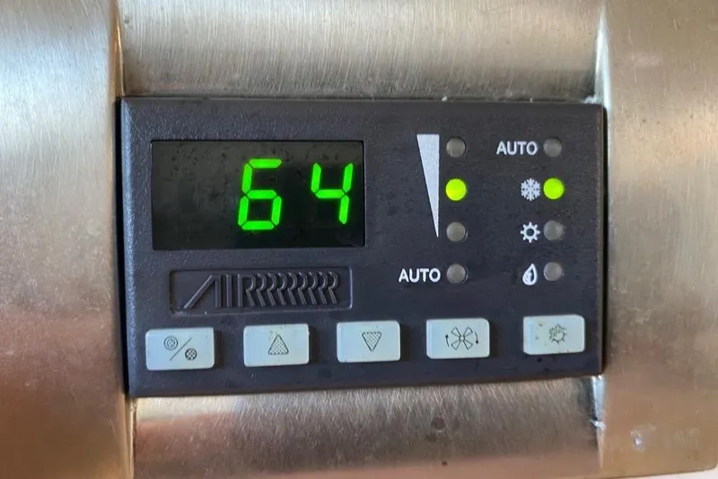 Slide: The Image of Digital control panel displaying temperature at 64 degrees on a 2016 Grady-White Canyon 336. - 38