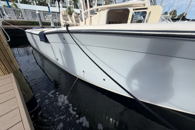 Slide: The Image of 2016 Grady-White Canyon 336 boat docked, side view with water reflection. - 4