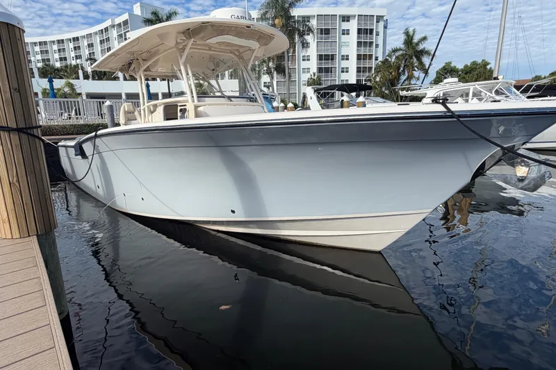 Slide: The Image of 2016 Grady-White Canyon 336 boat docked at marina, with modern buildings in background. - 5