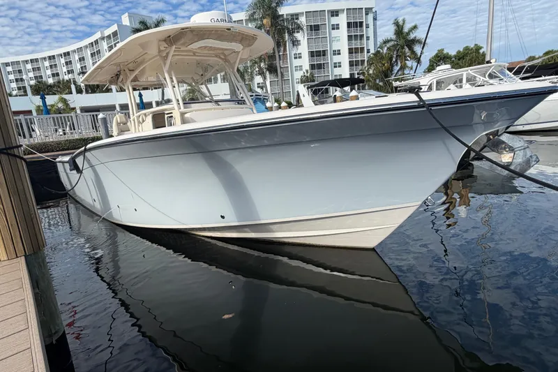 Slide: The Image of 2016 Grady-White Canyon 336 boat docked at marina with modern buildings in background. - 6