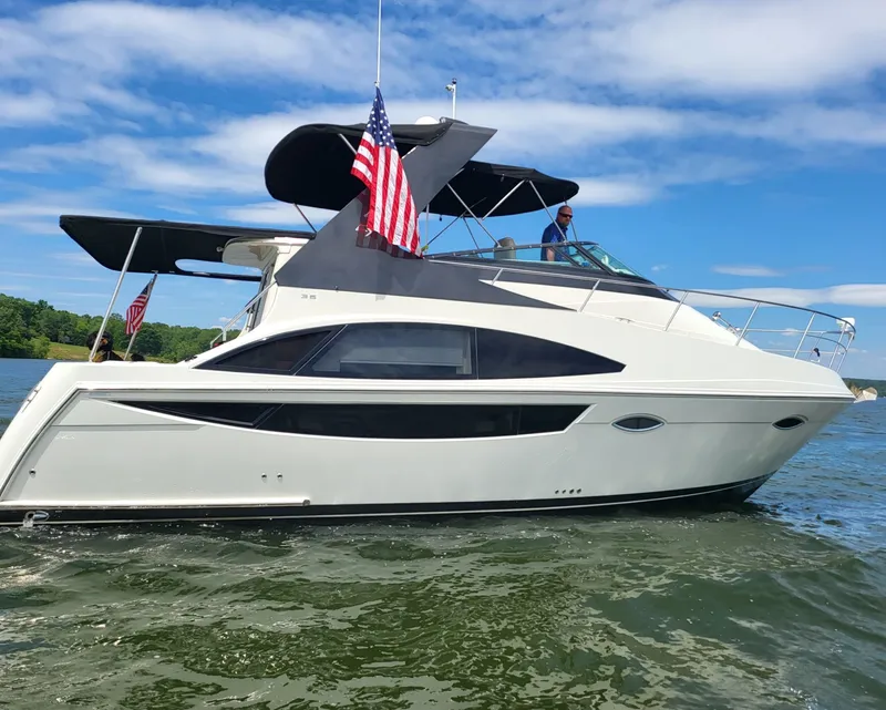 The Image of Carver 36 Mariner 2012 on calm water with American flag. - 0