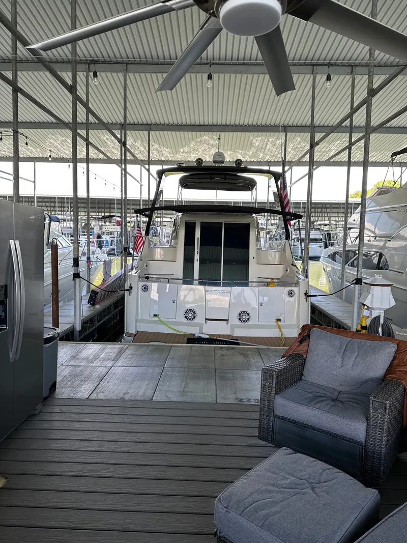 Slide: The Image of Carver 36 Mariner 2012 docked in covered marina with seating area. - 6