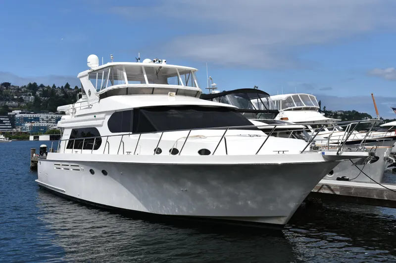 Slide: The Image of 2004 Ocean Alexander 64 Pilothouse yacht docked in a marina under a clear blue sky. - 1