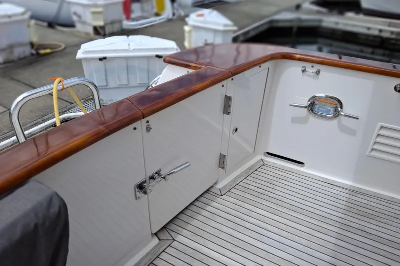 Slide: The Image of 2004 Ocean Alexander 64 Pilothouse yacht deck with polished wood and stainless steel fittings. - 7