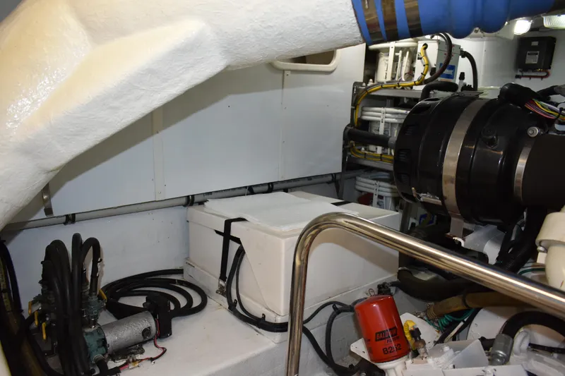 Slide: The Image of Engine room of 2004 Ocean Alexander 64 Pilothouse yacht, showcasing mechanical components and wiring. - 76