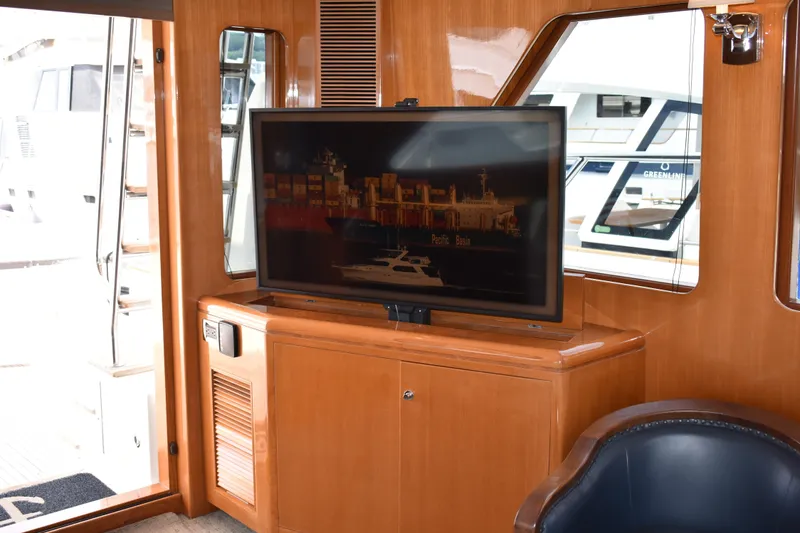 Slide: The Image of Luxurious interior of 2004 Ocean Alexander 64 Pilothouse yacht with TV and wooden cabinetry. - 48
