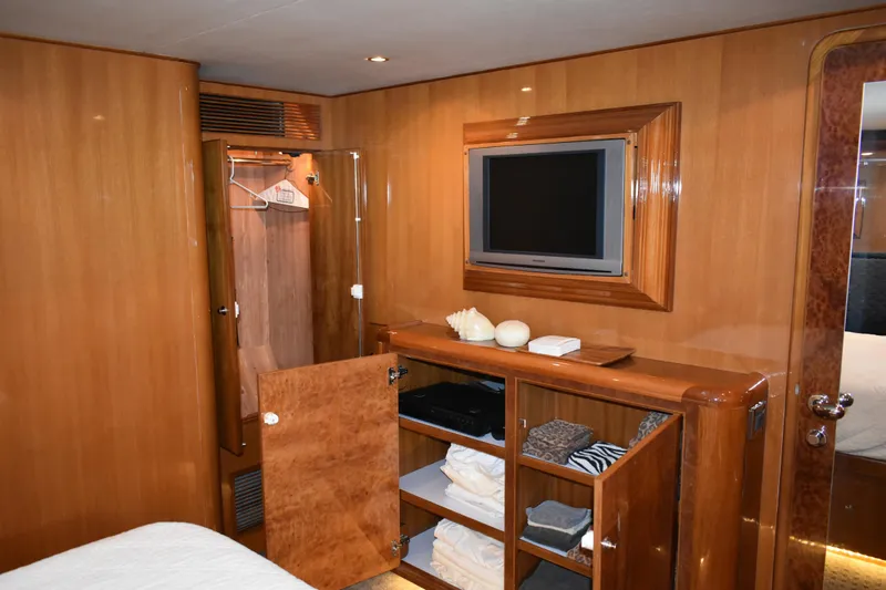 Slide: The Image of Luxurious 2004 Ocean Alexander 64 Pilothouse yacht interior with wooden cabinetry and TV. - 56