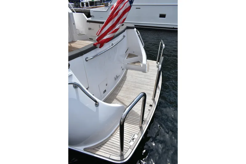 Slide: The Image of 2004 Ocean Alexander 64 Pilothouse yacht stern with American flag and teak deck. - 4