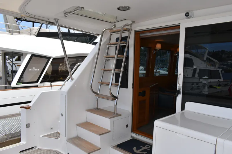Slide: The Image of 2004 Ocean Alexander 64 Pilothouse yacht with stainless steel ladder and open cabin door. - 8