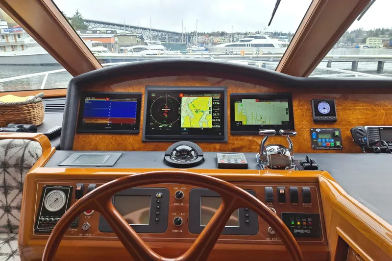 Slide: The Image of Pilothouse of 2004 Ocean Alexander 64, featuring navigation screens and controls, overlooking marina. - 36