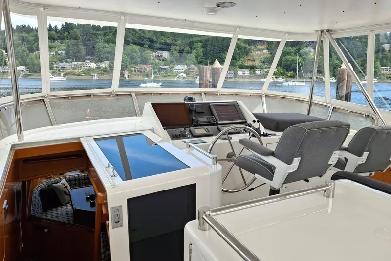 Slide: The Image of Pilothouse interior of 2004 Ocean Alexander 64, featuring helm and panoramic windows. - 20