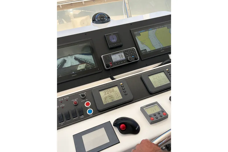 Slide: The Image of Pilothouse controls of a 2004 Ocean Alexander 64, featuring navigation and communication equipment. - 26
