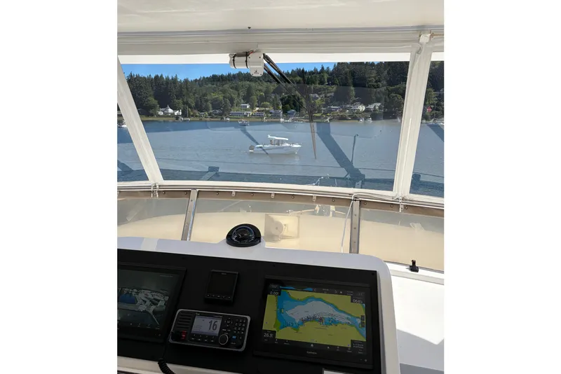 Slide: The Image of Pilothouse view from 2004 Ocean Alexander 64, overlooking serene waters and distant shoreline. - 21