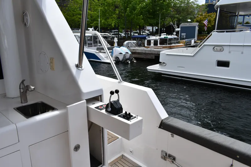 Slide: The Image of 2004 Ocean Alexander 64 Pilothouse yacht docked, featuring outdoor sink and control panel. - 16