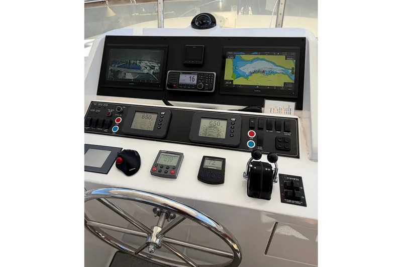 Slide: The Image of Pilothouse controls of 2004 Ocean Alexander 64, featuring navigation screens and steering wheel. - 25
