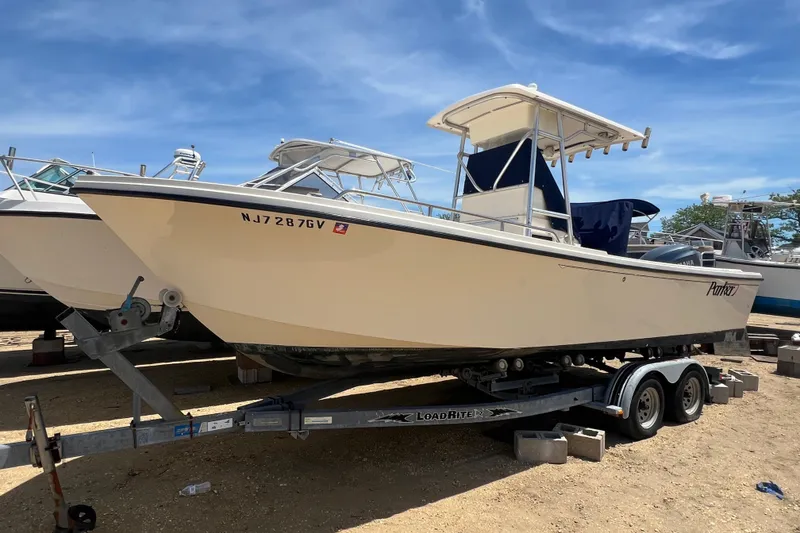 The Image of 2004 Parker 2300 Special Edition boat on trailer under clear blue sky. - 0