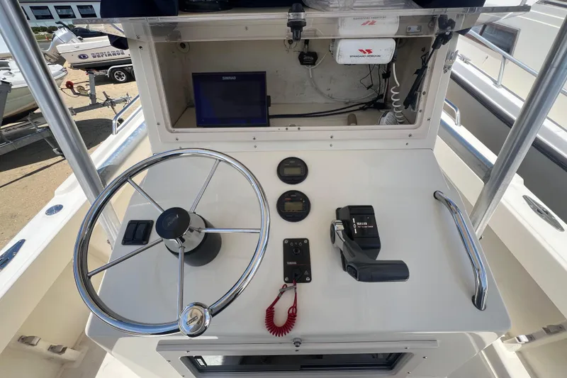 Slide: The Image of 2004 Parker 2300 Special Edition boat helm with steering wheel, controls, and navigation equipment. - 10