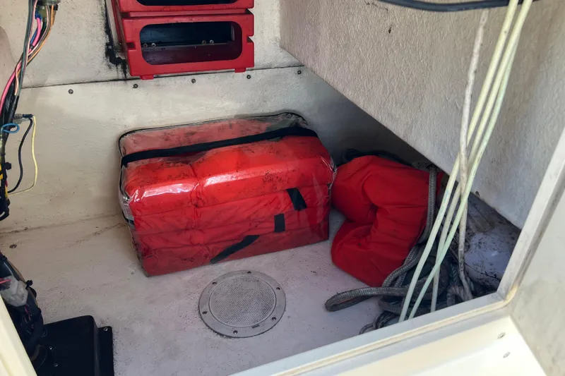 Slide: The Image of Storage compartment of a 2004 Parker 2300 Special Edition boat with safety equipment. - 14