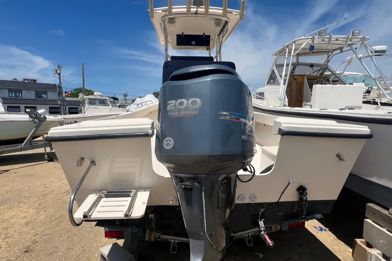Slide: The Image of 2004 Parker 2300 Special Edition boat with 200 horsepower engine, docked under clear blue sky. - 2