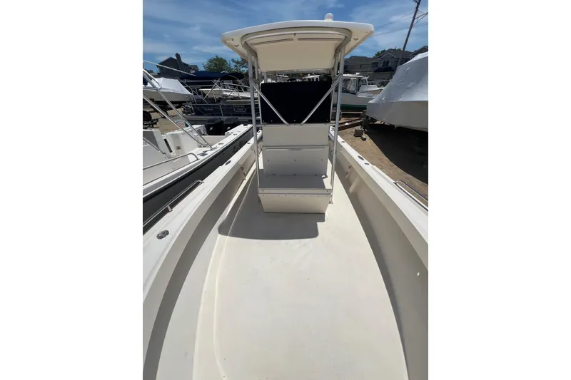 Slide: The Image of 2004 Parker 2300 Special Edition boat with center console and T-top, docked outdoors. - 7