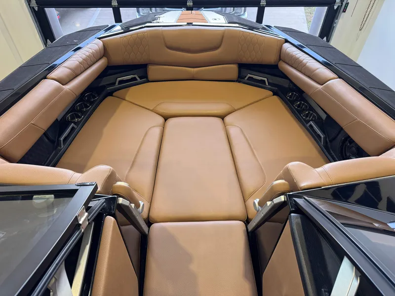 Slide: The Image of Interior of a 2021 Malibu M240 boat with brown leather seating. - 15