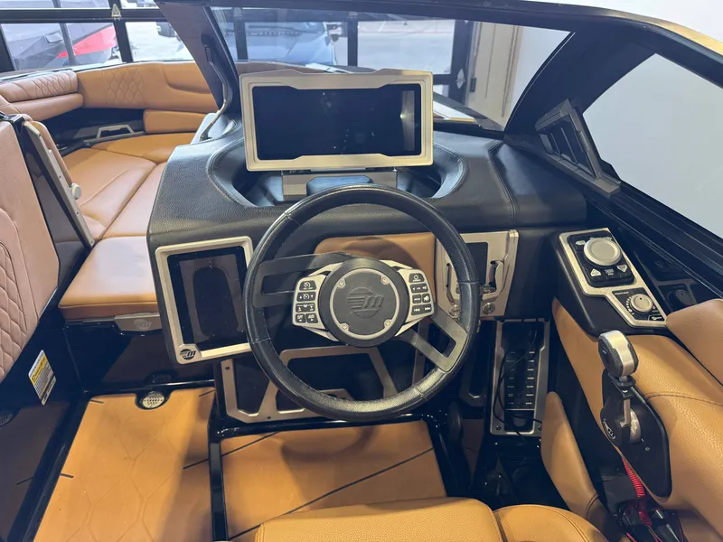 Slide: The Image of Interior of a 2021 Malibu M240 boat with steering wheel and control console. - 24