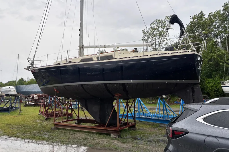 The Image of 1979 Aloha 34 sailboat on stands in a boatyard, overcast day. - 0