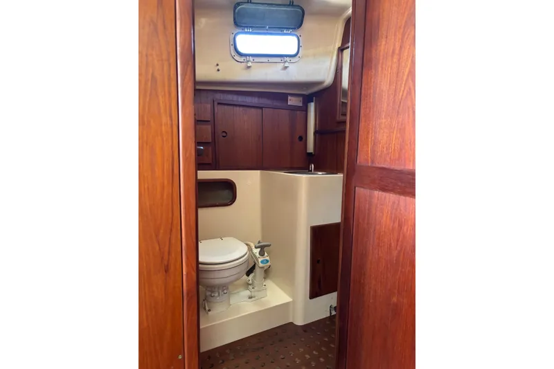 Slide: The Image of 1979 Aloha 34 sailboat bathroom with wooden cabinetry and compact toilet. - 10