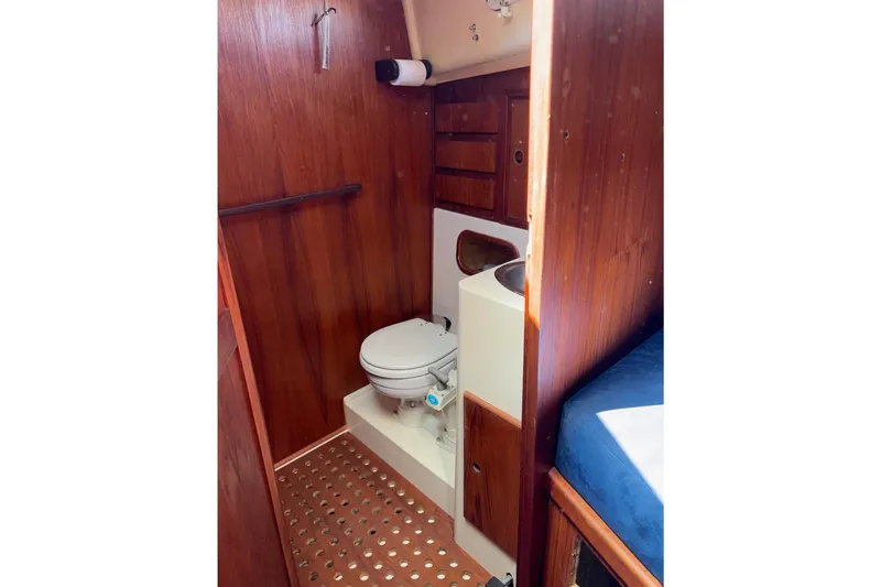 Slide: The Image of 1979 Aloha 34 sailboat bathroom with wooden paneling and compact toilet. - 11