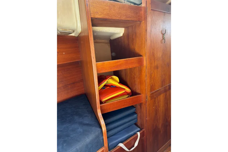 Slide: The Image of Wooden interior shelving with life jackets in a 1979 Aloha 34 sailboat. - 12