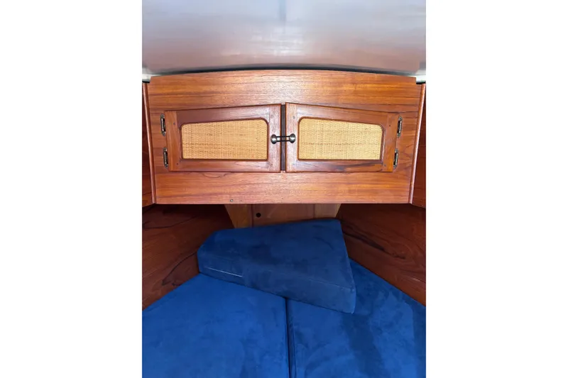 Slide: The Image of Interior of 1979 Aloha 34 sailboat with wooden cabinet and blue cushions. - 13