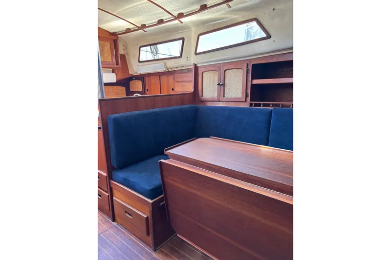 Slide: The Image of Interior of a 1979 Aloha 34 sailboat with wooden cabinetry and blue seating. - 14