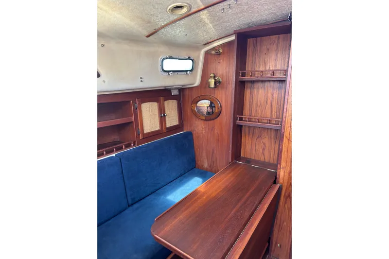 Slide: The Image of Interior of 1979 Aloha 34 sailboat with wooden cabinetry and blue seating. - 16