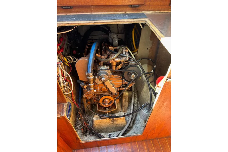 Slide: The Image of Engine compartment of a 1979 Aloha 34 sailboat, showcasing mechanical components and wiring. - 19