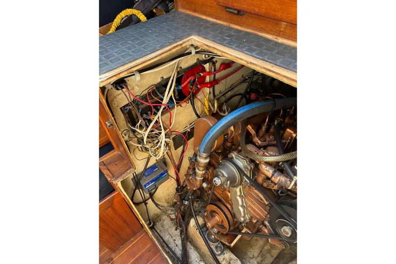 Slide: The Image of Engine compartment of a 1979 Aloha 34 sailboat, showcasing wiring and mechanical components. - 20
