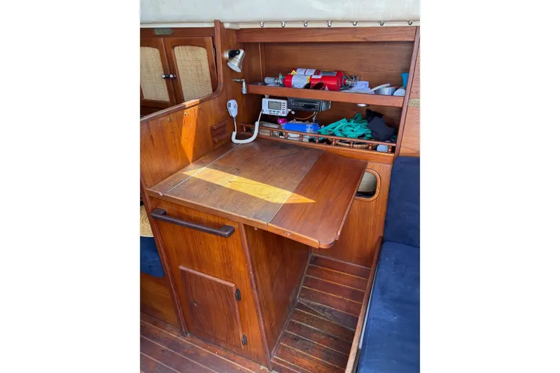 Slide: The Image of Interior of a 1979 Aloha 34 sailboat with wooden cabinetry and navigation equipment. - 24