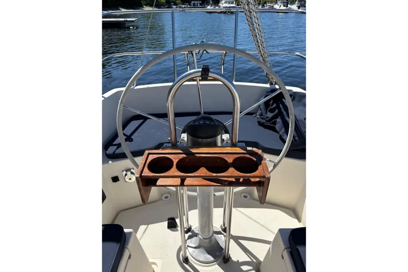 Slide: The Image of Steering wheel of a 1979 Aloha 34 sailboat with wooden cup holder on deck. - 25