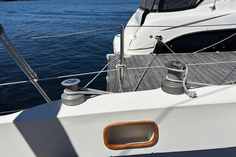 Slide: The Image of Sailboat deck with winches, docked beside another boat, Aloha 34, 1979 model. - 29