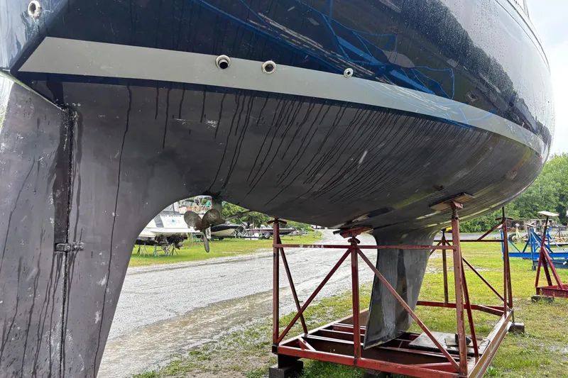 Slide: The Image of 1979 Aloha 34 sailboat on stands, showing hull and keel in a boatyard. - 3