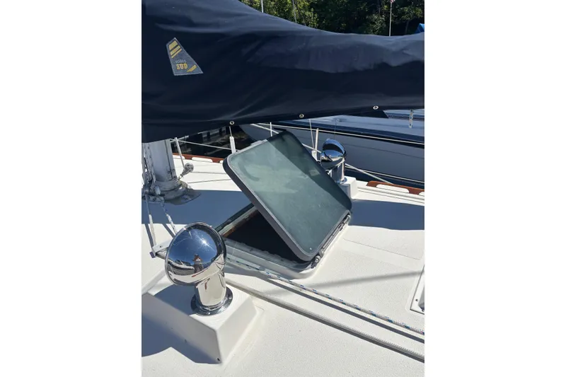 Slide: The Image of 1979 Aloha 34 sailboat deck with open hatch and covered mast. - 33