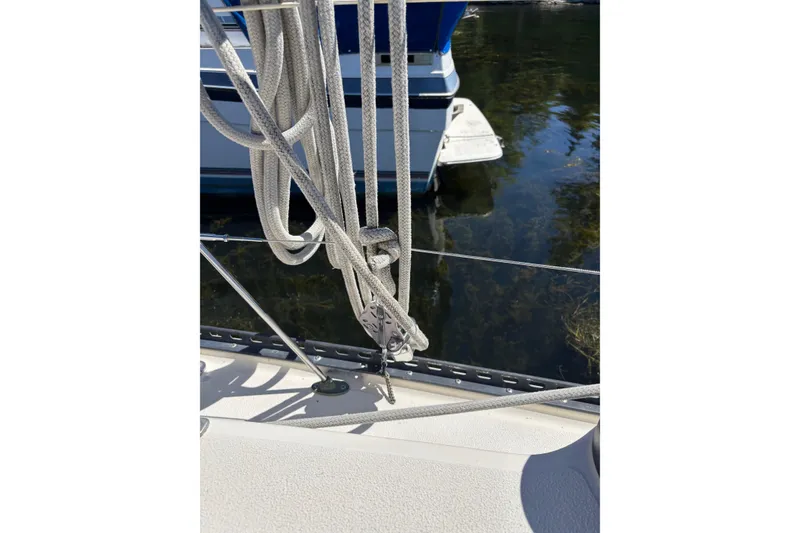 Slide: The Image of Rope and rigging on a 1979 Aloha 34 sailboat, docked near calm water. - 43