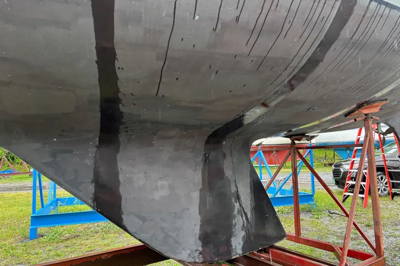 Slide: The Image of Close-up of a 1979 Aloha 34 sailboat hull on stands, showing keel and supports. - 5