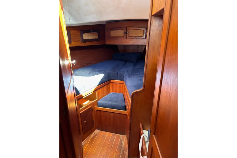 Slide: The Image of Cozy cabin interior of 1979 Aloha 34 sailboat with wooden finish and blue cushions. - 9