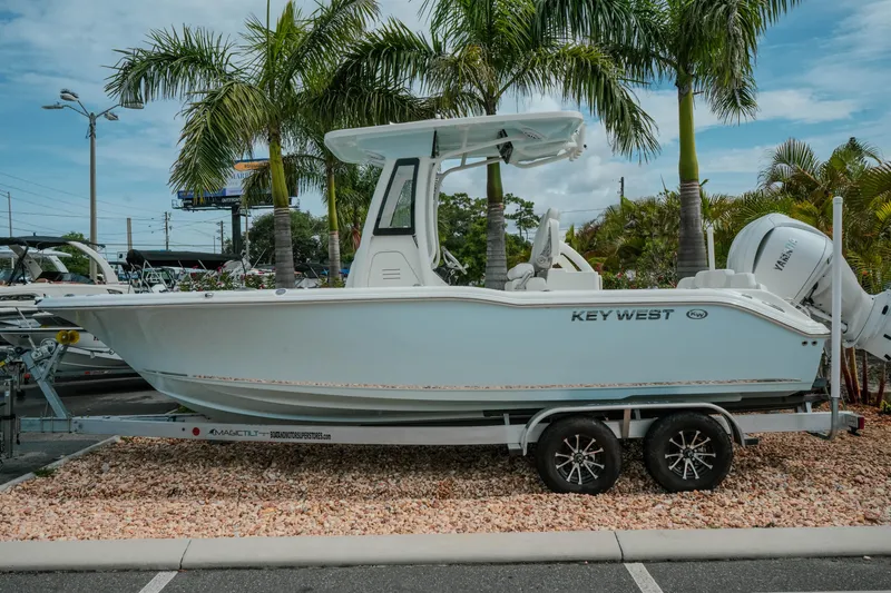 The Image of 2026 Key West 239 FSR boat on trailer, parked near palm trees. - 1