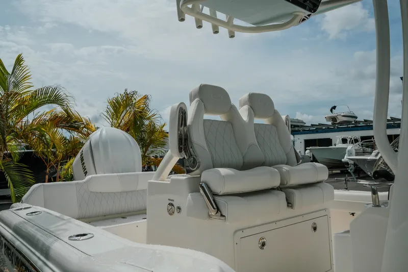 Slide: The Image of 2026 Key West 239 FSR boat interior with plush seating and palm trees in the background. - 10
