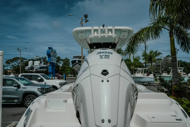 Slide: The Image of 2026 Key West 239 FSR boat with powerful engine, parked near palm trees. - 13